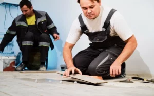 This image depicts a men installing Hardwood Flooring